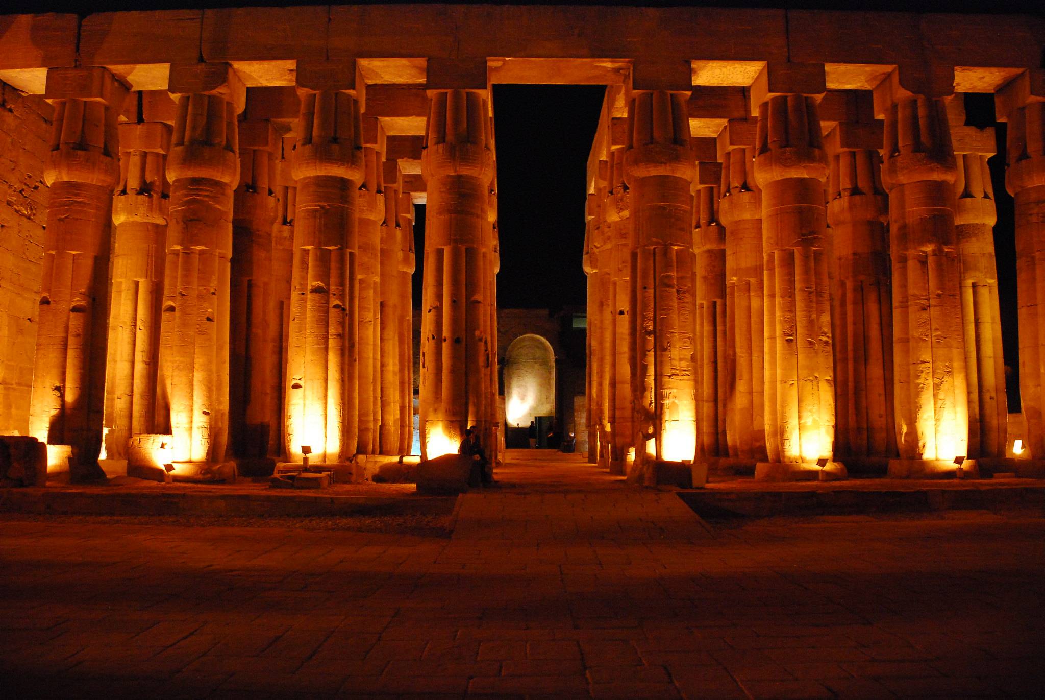 The beautifully lit colonnade hall of Luxor Temple at night.