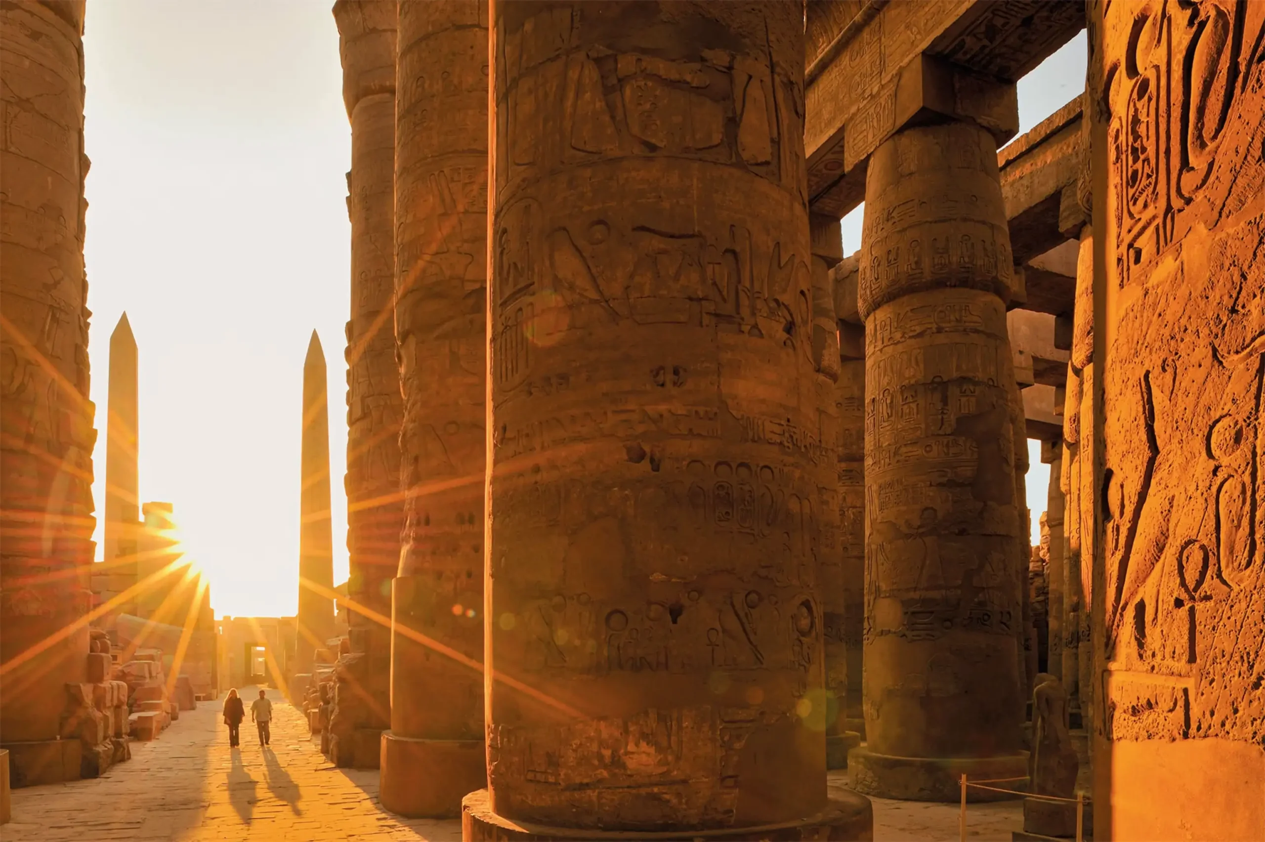 The sun rising behind the great columns of the Karnak Temple Complex.