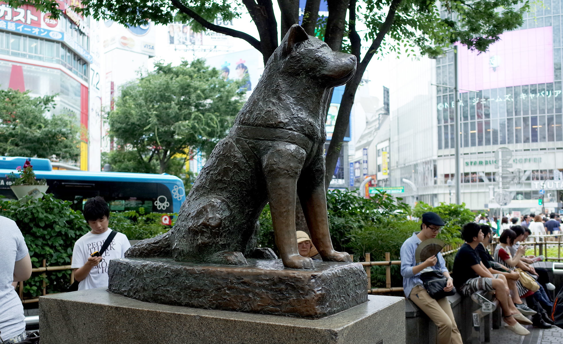 The famous Hachiko statue surrounded by people in front of Shibuya Station.