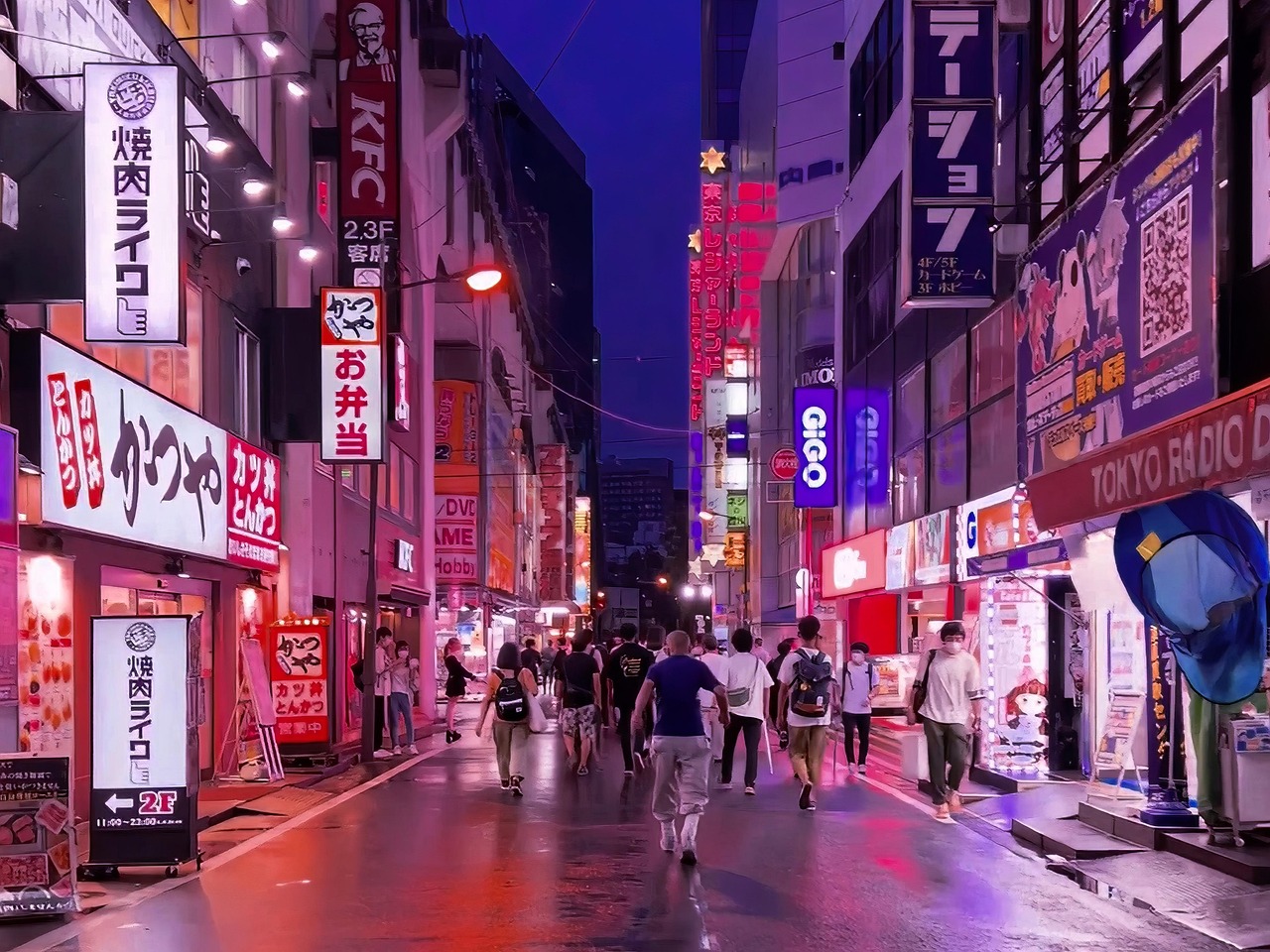 A bustling street in Akihabara at night, with towering buildings covered in bright anime billboards and colorful electronic signs, reflecting in the wet pavement.