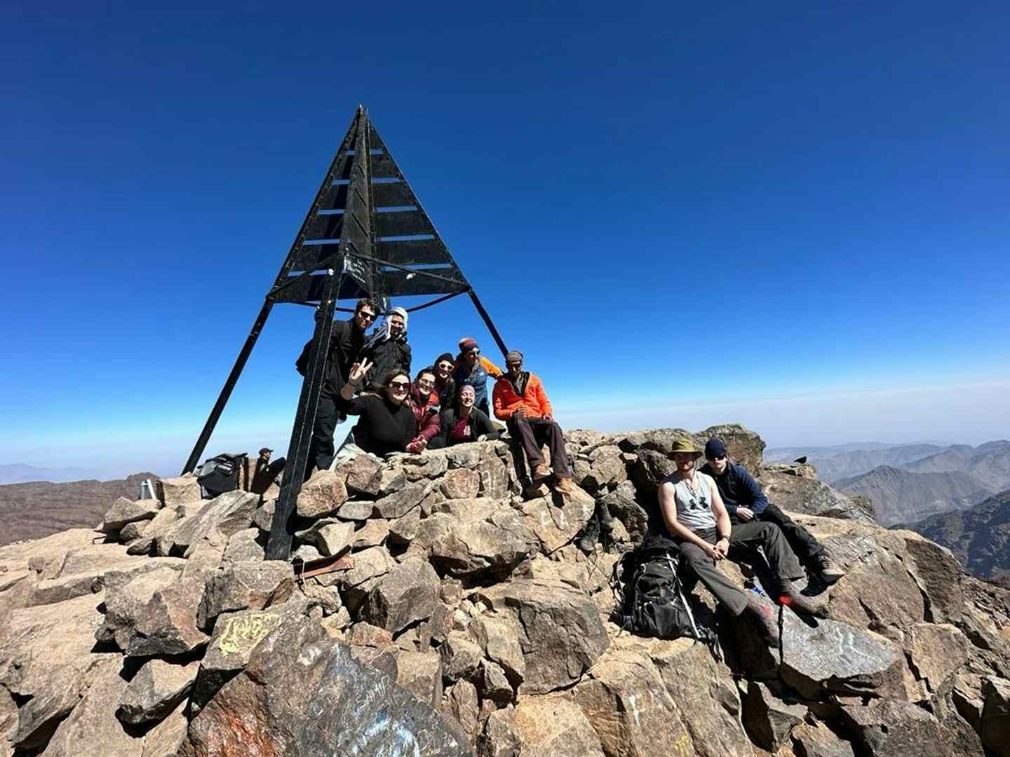 A hiker standing on the snow-covered summit of Mount Toubkal.