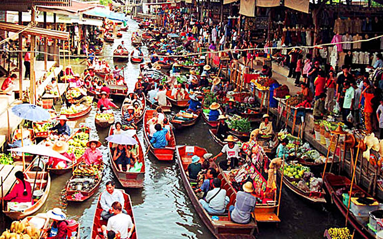 A vibrant scene at Damnoen Saduak Floating Market with boats and vendors.