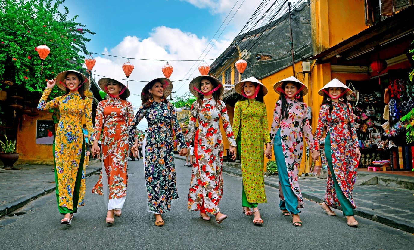 An example of traditional Hoi An tailoring, with a person being fitted for a custom suit inside a bright, well-stocked shop.